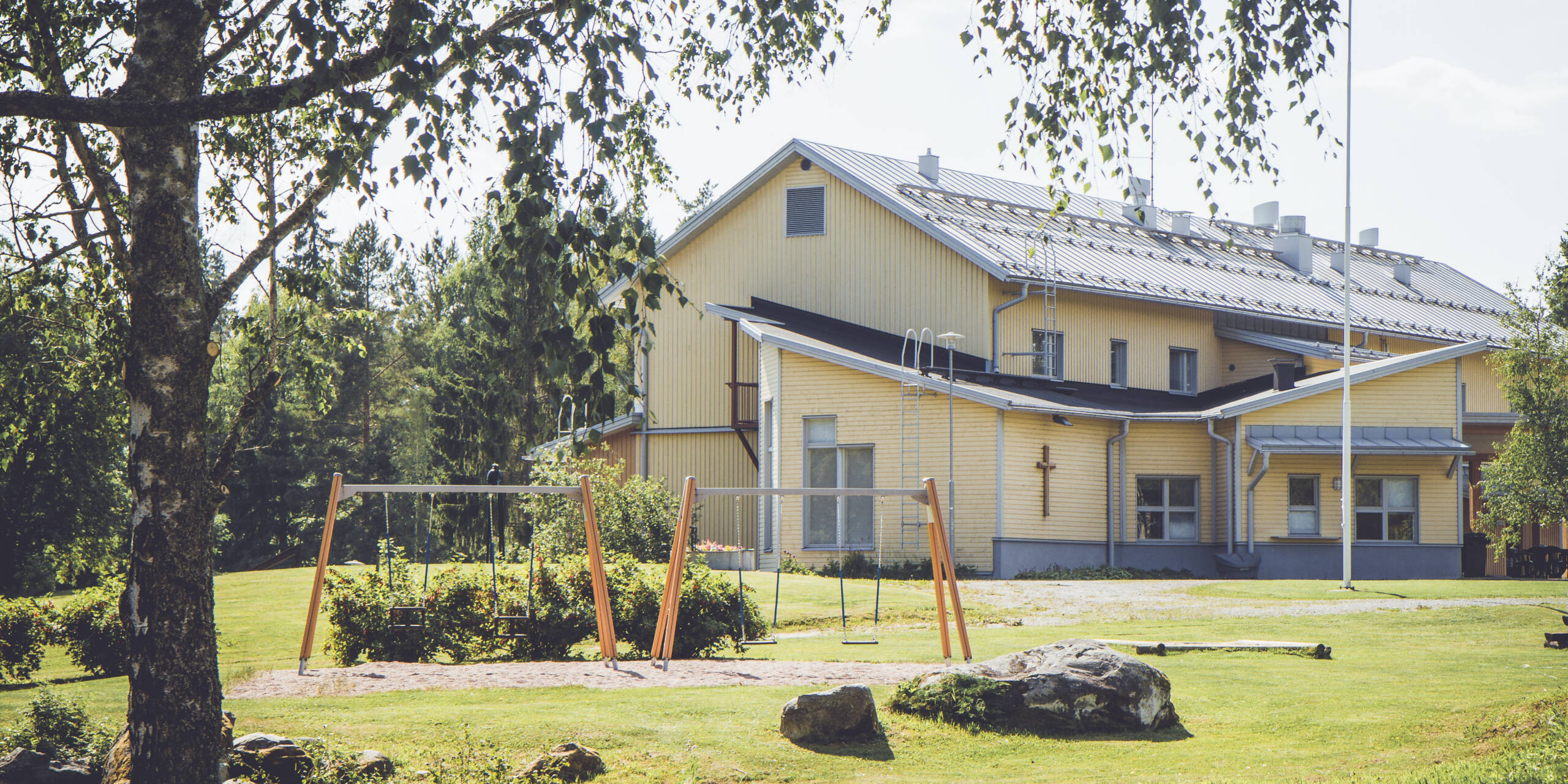 Pyysalon leirikeskuksen piha-aluetta ja päärakennuksen julkisivua kesällä.