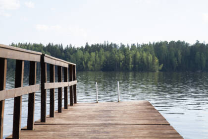 Laituri ja sen päässä järveen laskevat uimatikkaat.